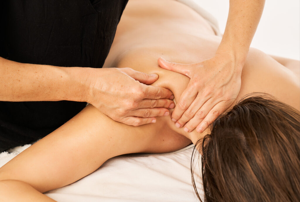 Massage therapist providing comfortable hands-on back treatment